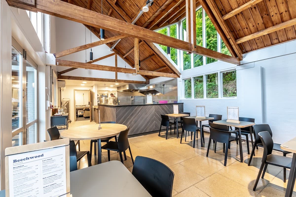 Inside Beechwood Kitchen at Queen Elizabeth Country Park, with timber roof beams and tables
