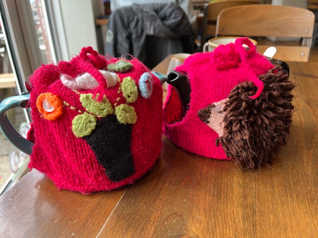 Knitted tea cosies on the tables at The Old Forge Tea Room, Hambledon