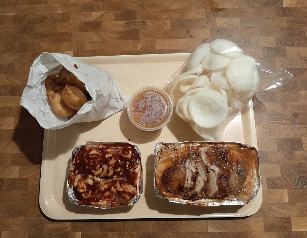 A Kim & Laurie Chinese takeaway order with prawn crackers, rice and mains in foil trays