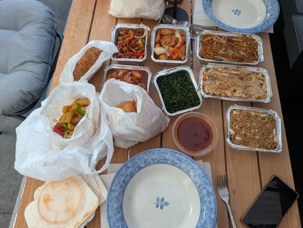 A New Golden Leaf takeaway spread of chow mein, rice and side dishes laid out on a table