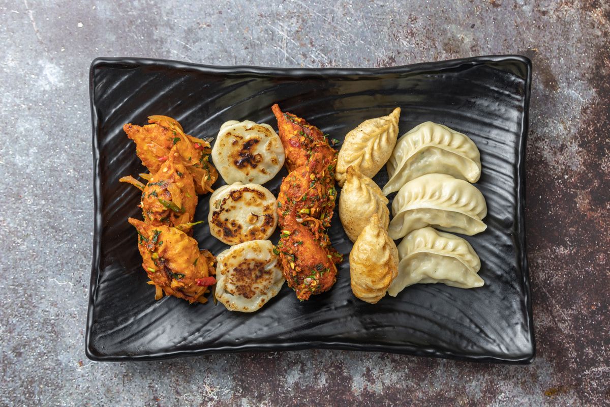 Chinese dumplings and starters on a plate, representative image